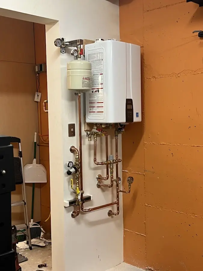 Plumbing technician inspecting water heater connections in Safford